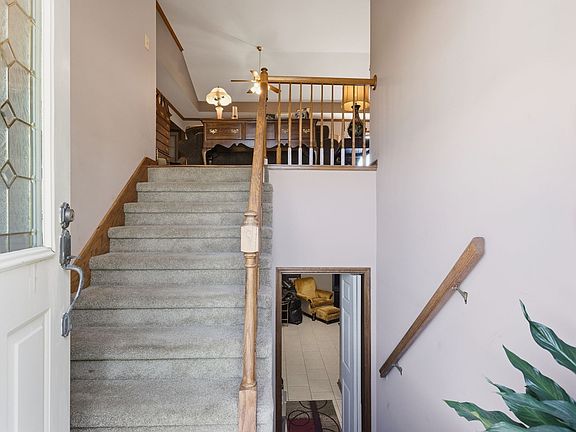 Interior split-foyer entry of 1474 Hardison Rd, looking up the carpeted staircase toward the upper living level and down toward a finished lower room
